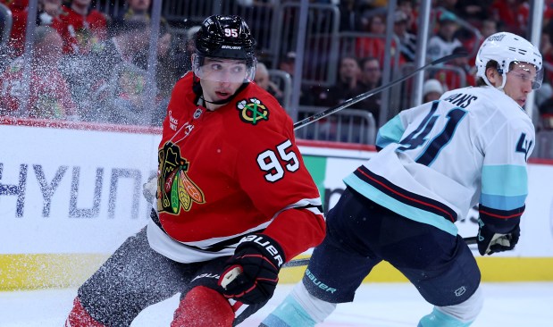 Blackhawks right wing Ilya Mikheyev looks for the puck while battling Kraken defenseman Ryker Evans on Nov. 20, 2025, at the United Center. (Chris Sweda/Chicago Tribune)