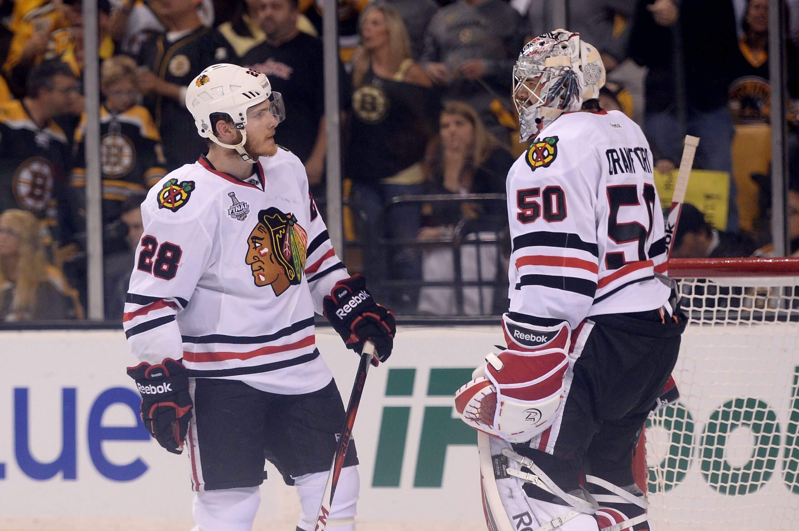 Forward Ben Smith talks to Blackhawks goalie Corey Crawford during a pause in play.