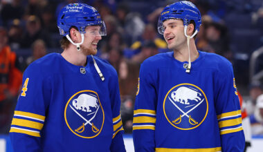 BUFFALO, NEW YORK - JANUARY 14: Bowen Byram #4 and Josh Norris #9 of the Buffalo Sabres share a laugh while warming up prior to an NHL game against the Philadelphia Flyers on January 14, 2026 at KeyBank Center in Buffalo, New York. (Photo by Bill Wippert/NHLI via Getty Images)
