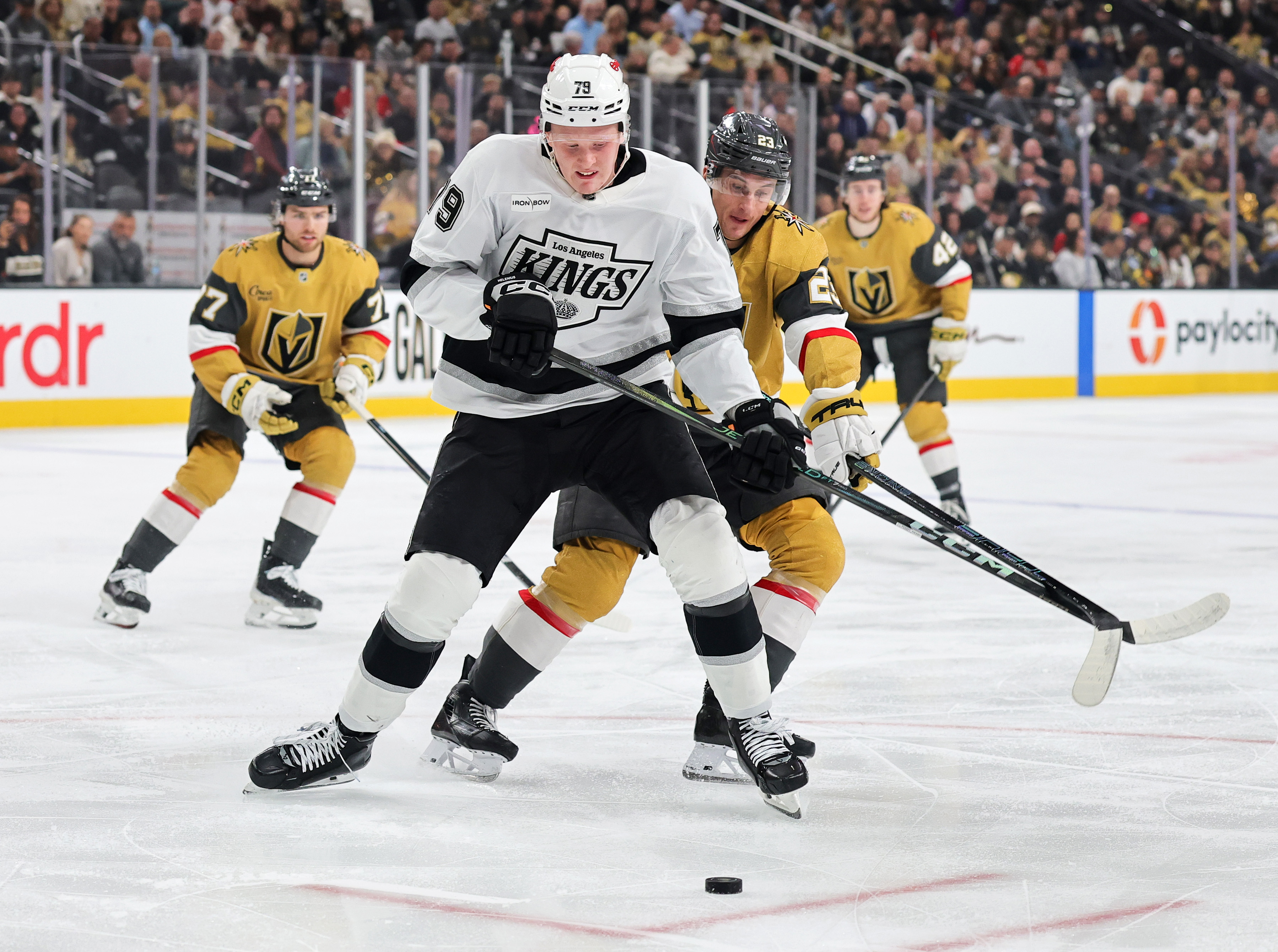 The Kings’ Samuel Helenius, front, skates with the puck while...