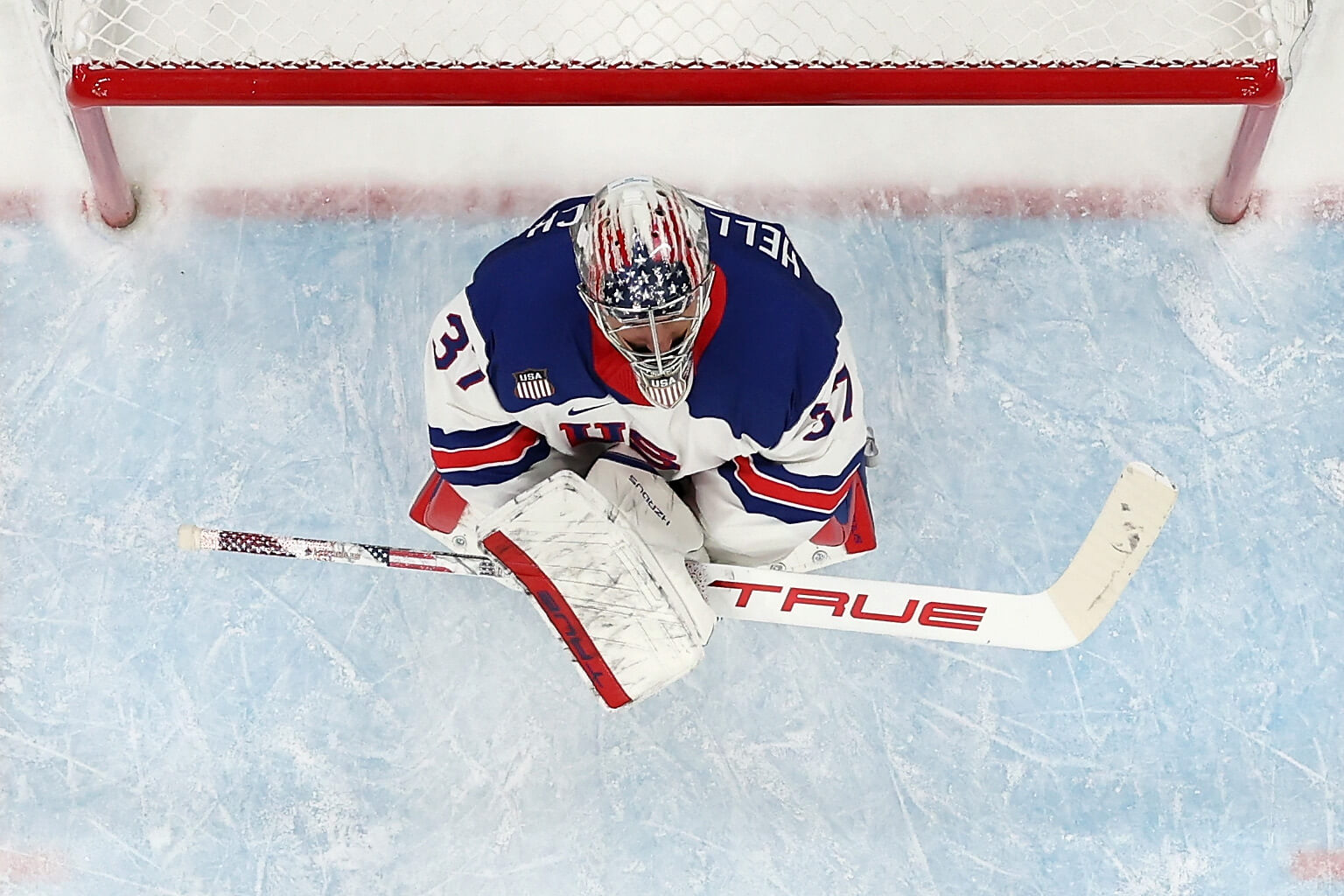 Bird's-eye shot of Connor Hellebuyck crouching in the USA net.