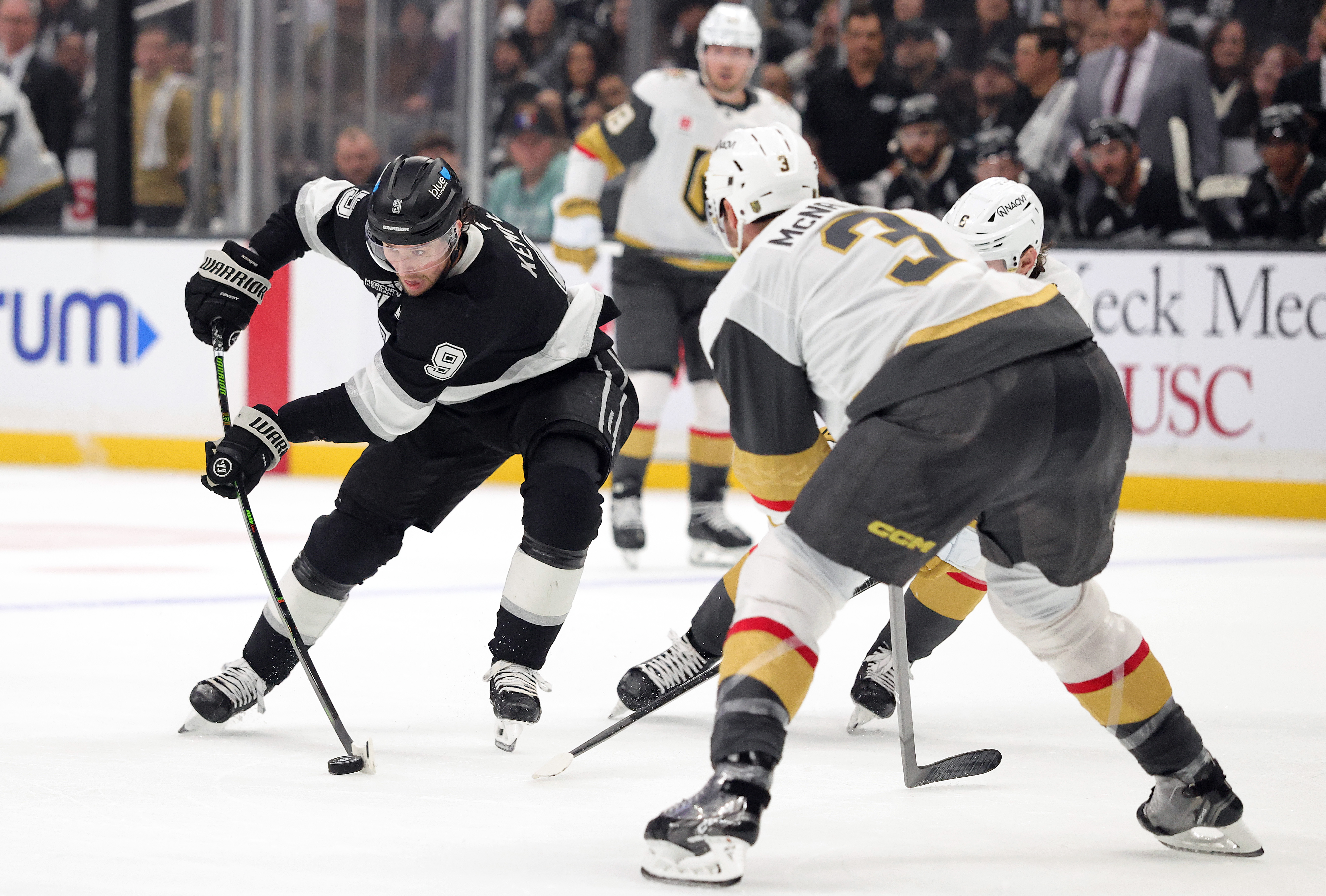 The Kings’ Adrian Kempe, left, skates with the puck during...