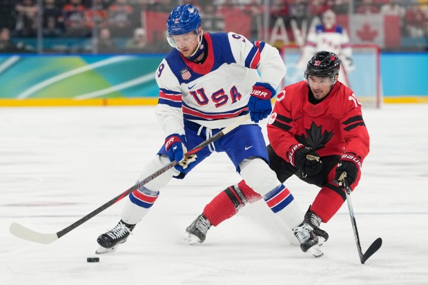 United States center Jack Eichel carries the puck against Canada's Nick Suzuki during a men's ice hockey gold medal game between Canada and the United States at the 2026 Winter Olympics, in Milan, Italy, Sunday, Feb. 22, 2026. (AP Photo/Hassan Ammar)