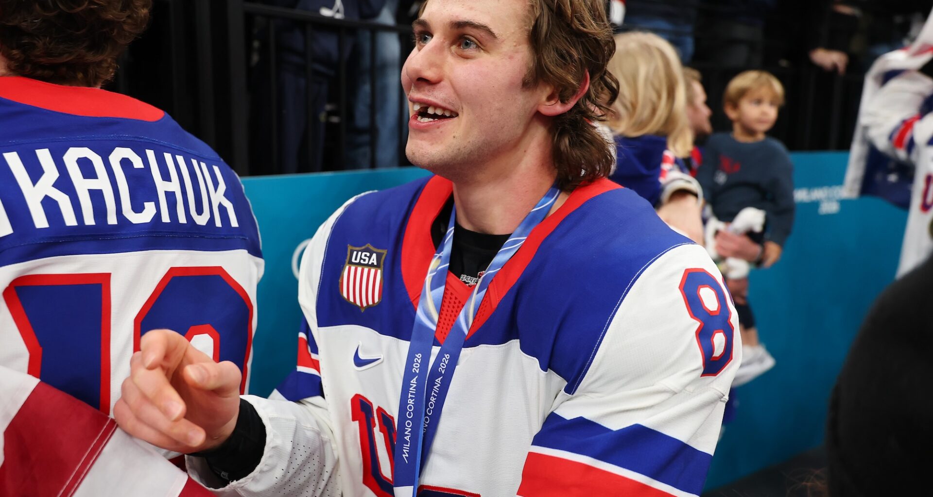 Jack Hughes wearing his gold medal smiling with his missing teeth
