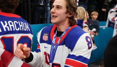 Jack Hughes wearing his gold medal smiling with his missing teeth