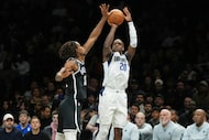 Dallas Mavericks' Khris Middleton (20) shoots over Brooklyn Nets' Nic Claxton (33) during...