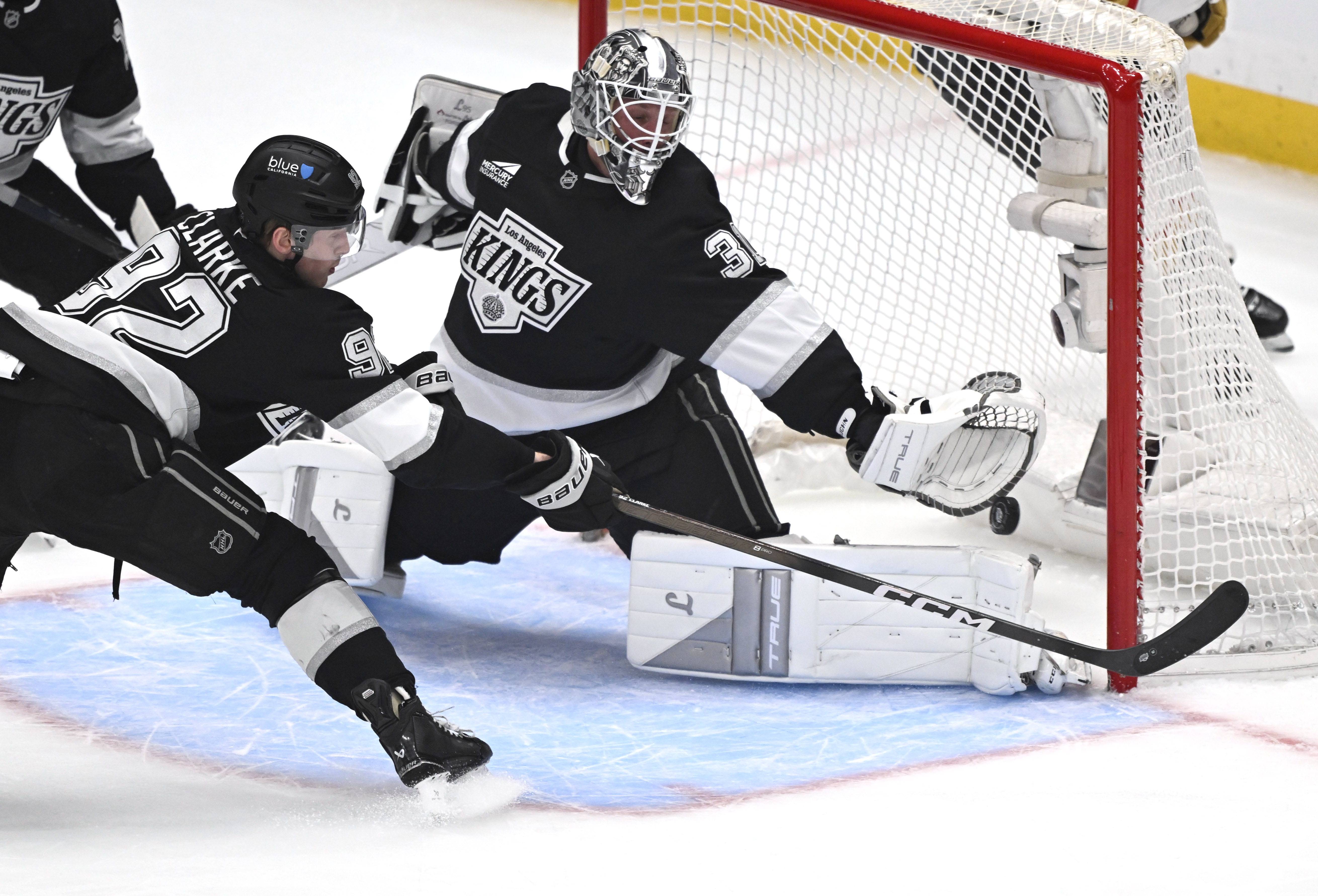 Kings goaltender Anton Forsberg, right, blocks a shot during the...