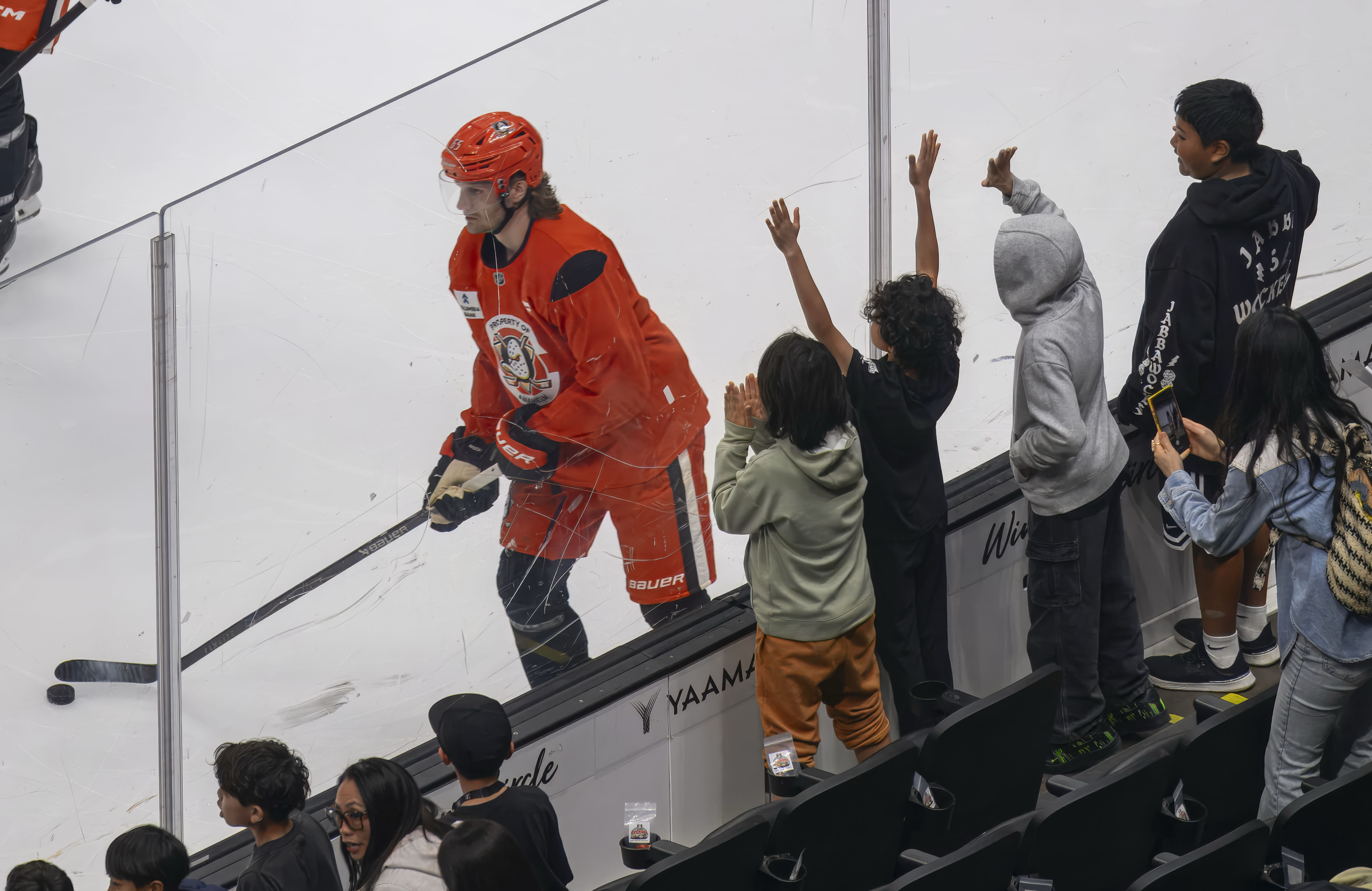 Elementary school kids cheer an Anaheim Ducks player during a...