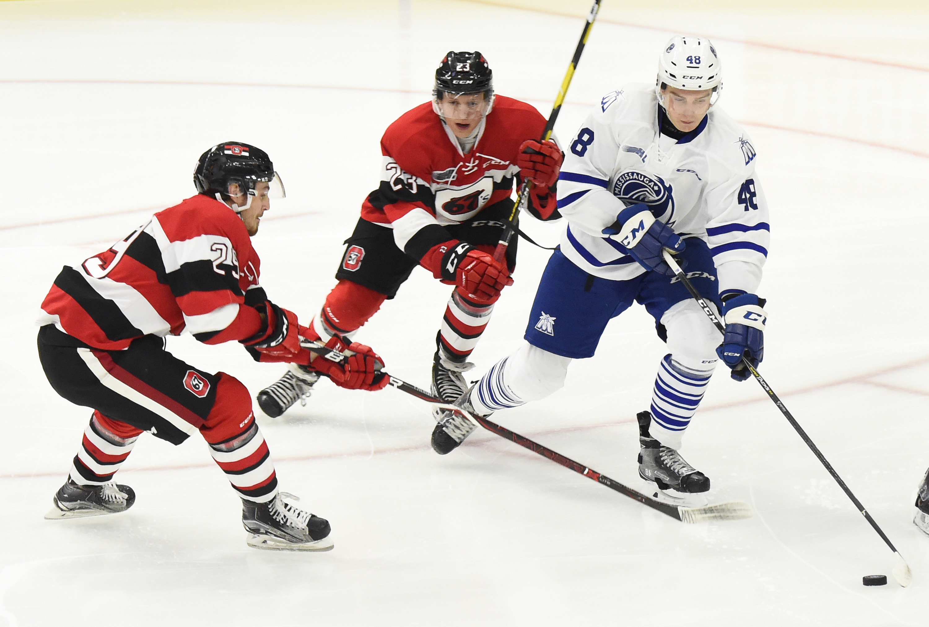 MISSISSAUGA, ON - OCTOBER 21: Thomas Harley #48 of the Mississauga Steelheads battles for the puck against Marco Rossi #23 \and Tye Felhaber #29 of the Ottawa 67s during OHL game action on October 21, 2018 at Paramount Fine Foods Centre in Mississauga, Ontario, Canada. (Photo by Graig Abel/Getty Images)