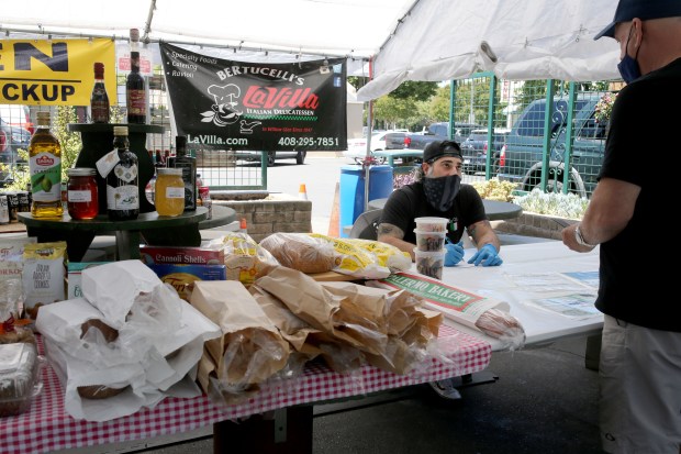 During COVID, La Villa operated a makeshift outdoor deli for customer safety. Here, co-owner Chris Bertucelli takes a food order from a customer. (Ray Chavez/Bay Area News Group)