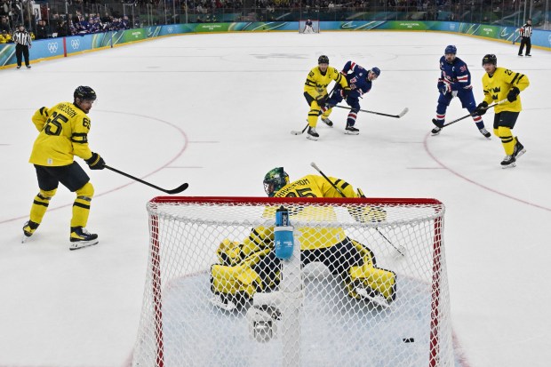 United States' Quinn Hughes (43) shoots and scores his team's second goal to win the men's ice hockey quarterfinal game between the United States and Sweden at the 2026 Winter Olympics, in Milan, Italy, Wednesday, Feb. 18, 2026. (Alexander Nemenov/Pool Photo via AP)