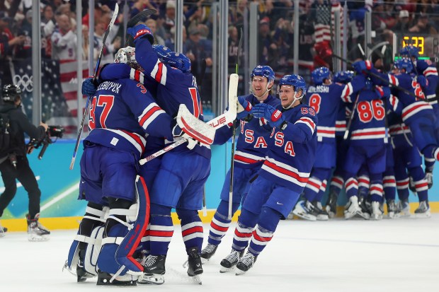 MILAN, ITALY - FEBRUARY 18: Players of Team United States congratulate Connor Hellebuyck #37 after defeating Sweden 2-1 in overtime during the Men's Quarterfinals Playoff match between the United States and Sweden on day 12 of the Milano Cortina 2026 Winter Olympic games at Milano Santagiulia Ice Hockey Arena on February 18, 2026 in Milan, Italy. (Photo by Gregory Shamus/Getty Images)