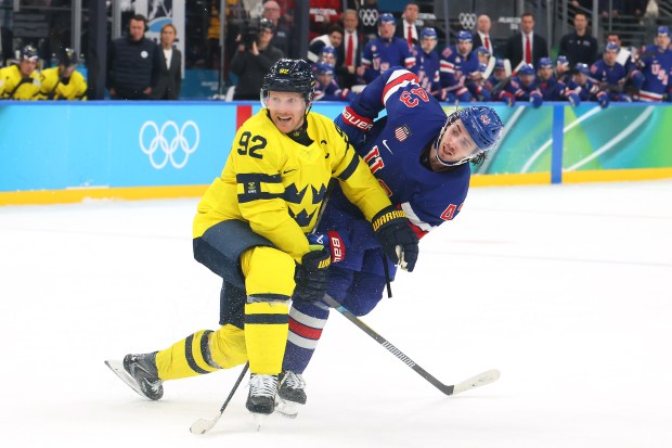 MILAN, ITALY - FEBRUARY 18: Quinn Hughes #43 of Team United States scores a goal defended by Gabriel Landeskog #92 of Team Sweden in overtime during the Men's Quarterfinals Playoff match between the United States and Sweden on day 12 of the Milano Cortina 2026 Winter Olympic games at Milano Santagiulia Ice Hockey Arena on February 18, 2026 in Milan, Italy. (Photo by Bruce Bennett/Getty Images)