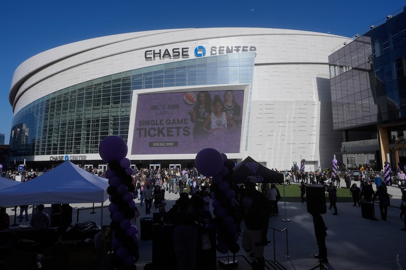 Fans walk outside Chase Center before a WNBA preseason basketball game between the Golden...