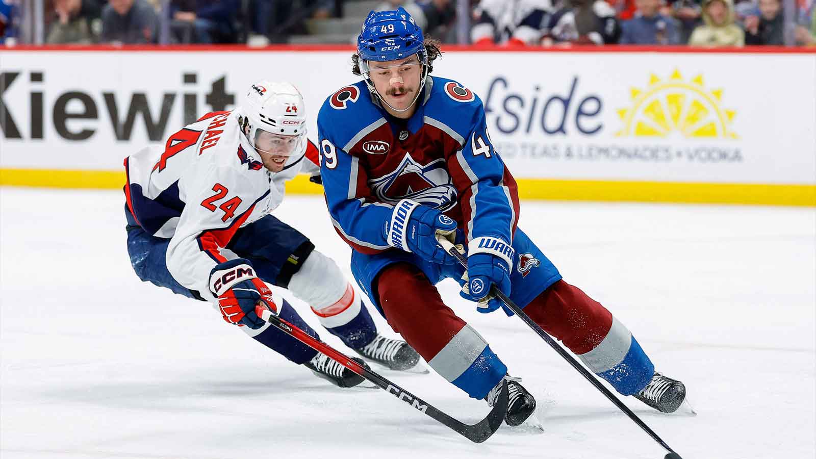Colorado Avalanche defenseman Samuel Girard (49) controls the puck ahead of Washington Capitals center Connor McMichael (24) in the first period at Ball Arena.
