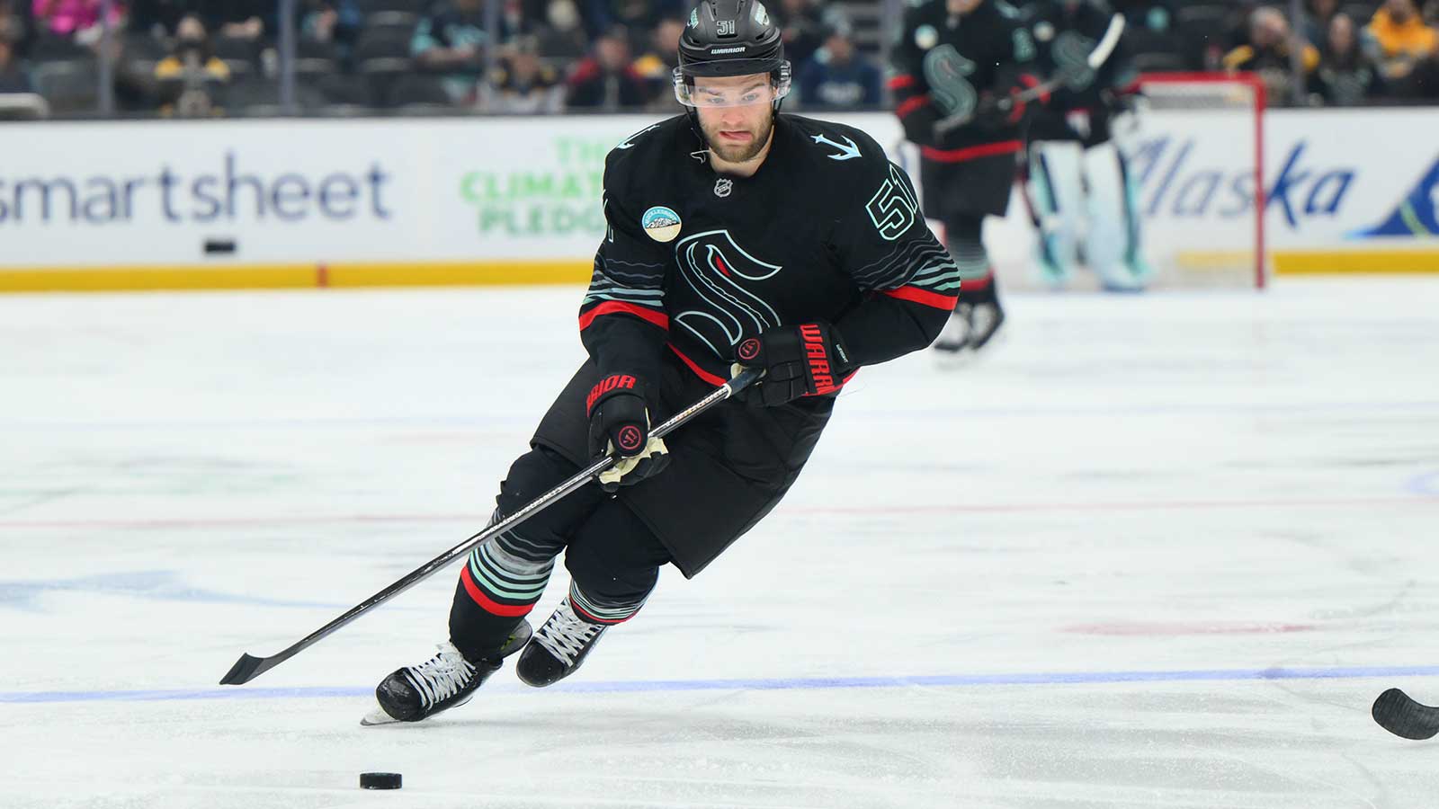Seattle Kraken center Shane Wright (51) advances the puck against the Boston Bruins during the second period at Climate Pledge Arena.
