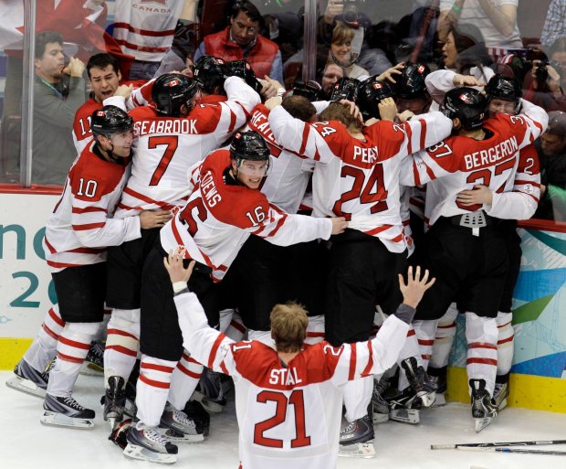 Canada's Sidney Crosby is mobbed by teammates after making the game-winning goal in the overtime period of a men's gold medal ice hockey game against USA at the Vancouver 2010 Olympics in Vancouver, British Columbia, Sunday, Feb. 28, 2010. Canada won 3-2. (AP Photo/Chris O'Meara)