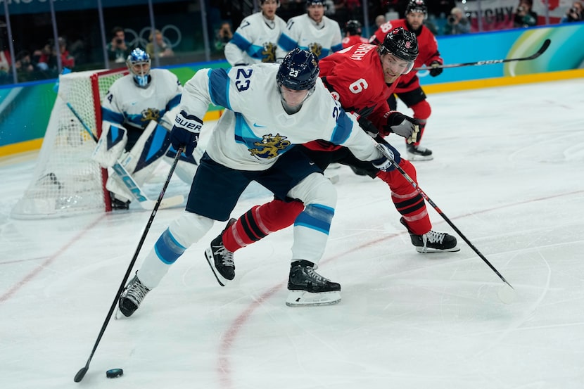 Finland's Esa Lindell (23) challenges for the puck with Canada's Travis Sanheim (6) during a...