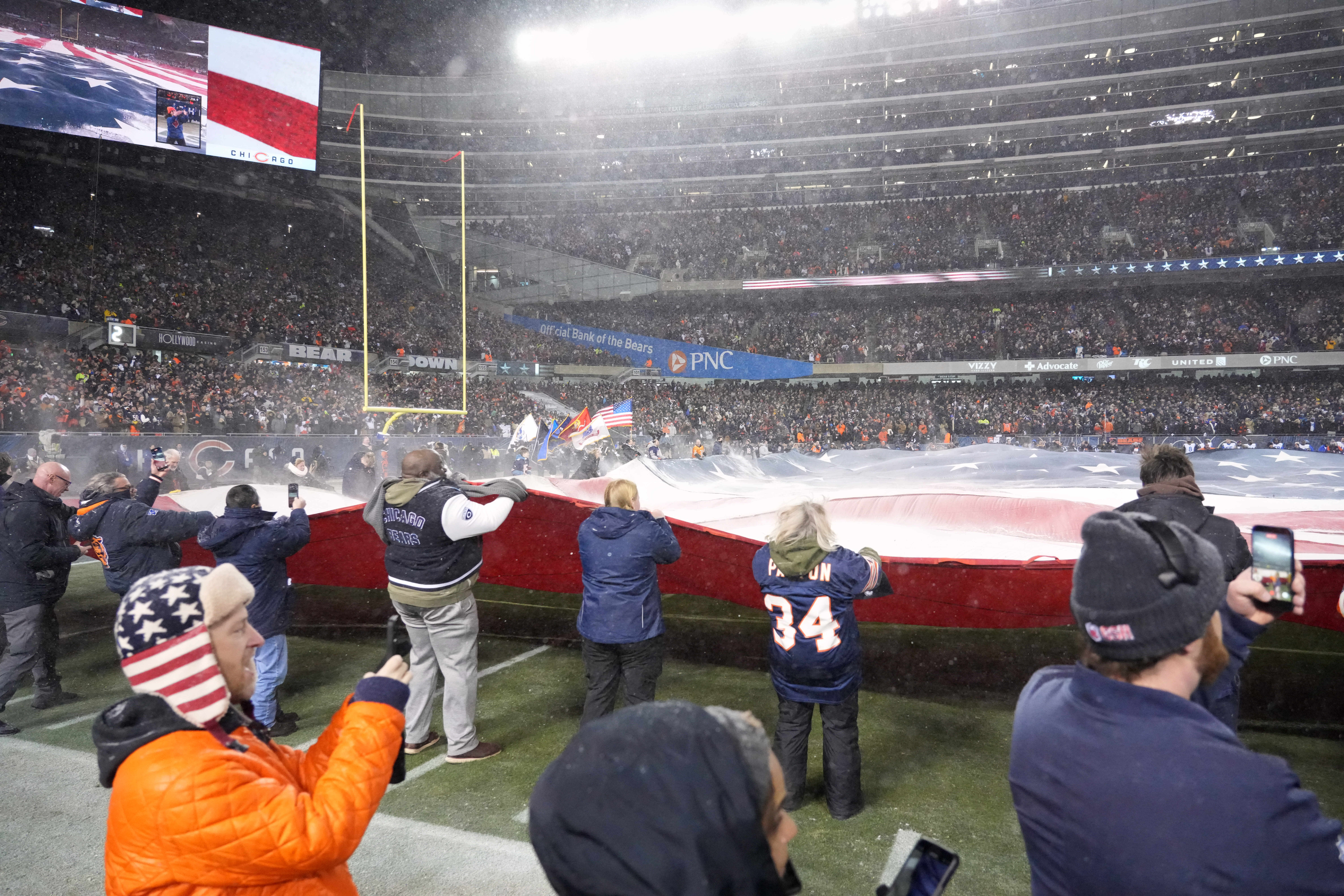 Jan 18, 2026; Chicago, IL, USA; Fans hold a large American flag on the field before an NFC Divisional Round game between the Los Angeles Rams and the Chicago Bears at Soldier Field.