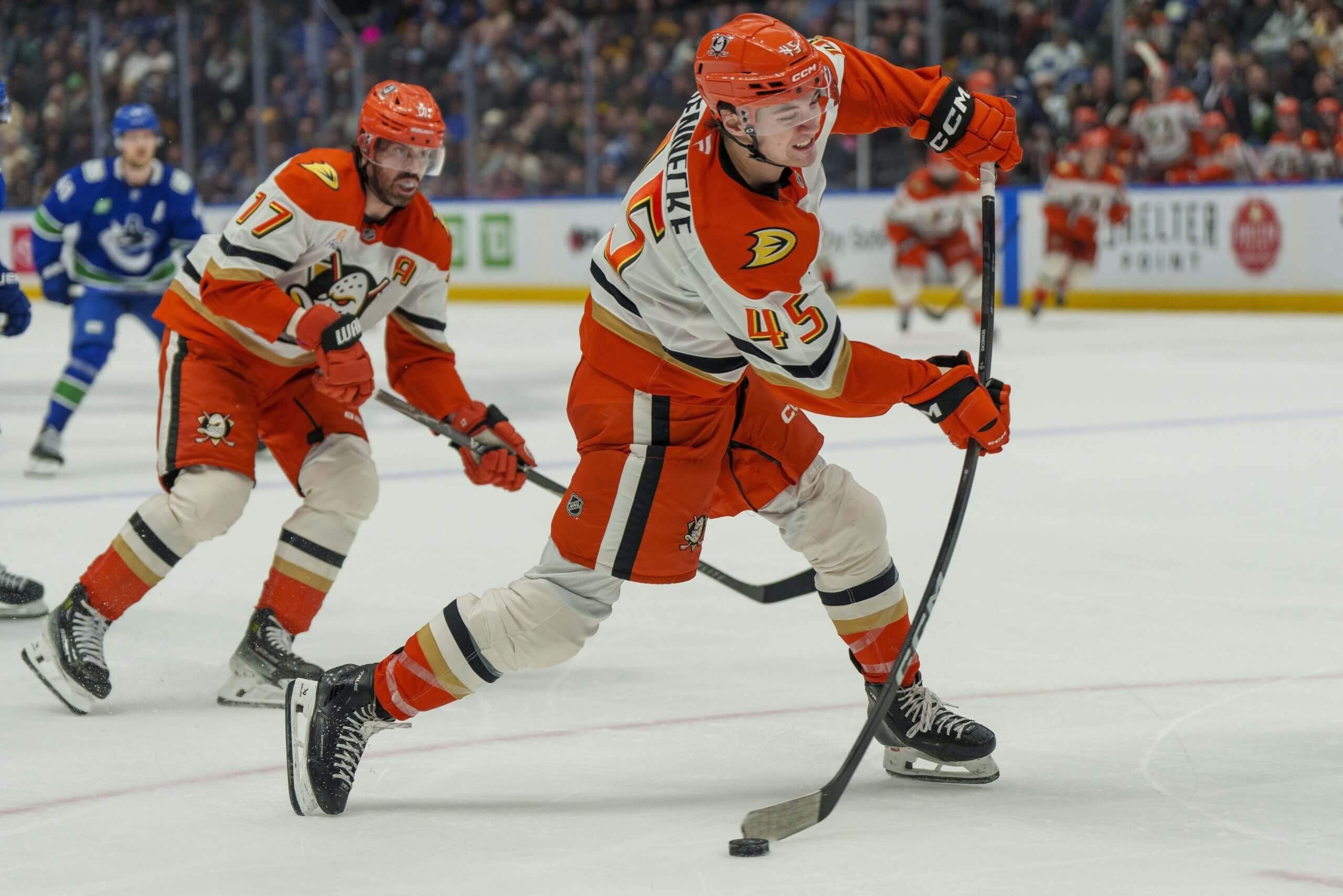 Beckett Sennecke releases a shot against the Canucks with a Ducks teammate skating behind.