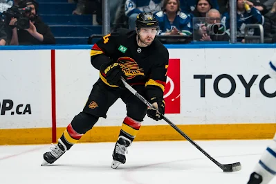 Vancouver Canucks forward Jake DeBrusk skates with the puck during 2025 game.