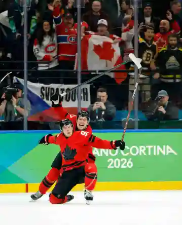Feb 18, 2026; Milan, Italy; Mitch Marner of Canada celebrates with Thomas Harley after scoring their fourth and game-winning goal against Czechia in a men's ice hockey quarterfinal during the Milano Cortina 2026 Olympic Winter Games at Milano Santagiulia Ice Hockey Arena. Mandatory Credit: Geoff Burke-Imagn Images