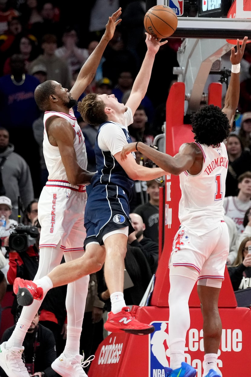 Dallas Mavericks forward Cooper Flagg (center) drives to the basket as Houston Rockets...