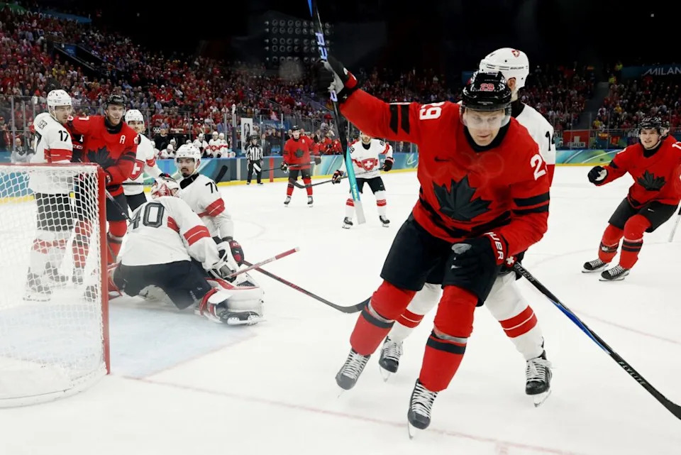 Feb 13, 2026; Milan, Italy; Nathan MacKinnon of Canada celebrates after scoring their fifth goal against Switzerland in men’s ice hockey group A play during the Milano Cortina 2026 Olympic Winter Games at Milano Santagiulia Ice Hockey Arena. Mandatory Credit: Geoff Burke-Imagn Images