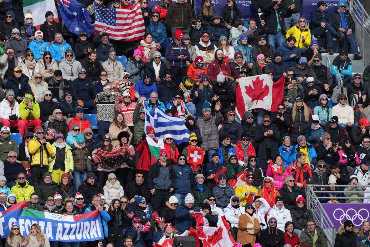 Skiing fans wave flags while watching the men's downhill race on February 7.