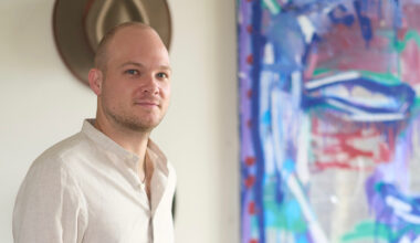 Oliver Barnett posing in front of a colorful painting