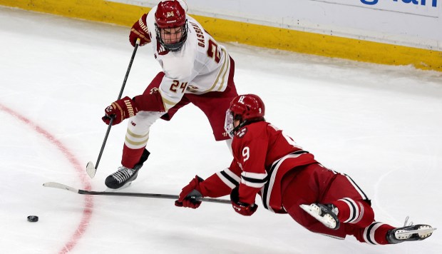 Ryan Healey of the Harvard Crimson dives for the puck in front of Andre Gasseau of the Boston College Eagles during the first period of the men's Beanpot semifinals at TD Garden. (Photo By Matt Stone/Boston Herald)