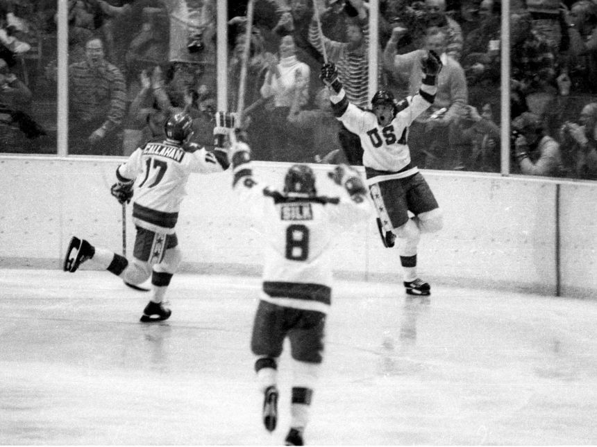 Team USA's Mark Johnson, right, celebrates one of his two goals vs. the Soviet Union during a medal round game at the 1980 Winter Olympics in Lake Placid, New York, on February 22, 1980. Johnson's teammates in the photo are #17 Jack O'Callahan and #8 Dave Silk.