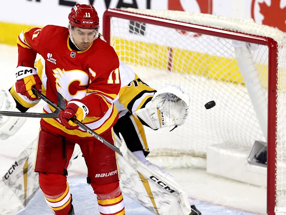  Calgary Flames centre Mikael Backlund battles Pittsburgh Penguins goalie Stuart Skinner in second-period NHL action at the Scotiabank Saddledome in Calgary on Wednesday, Jan. 21, 2026.