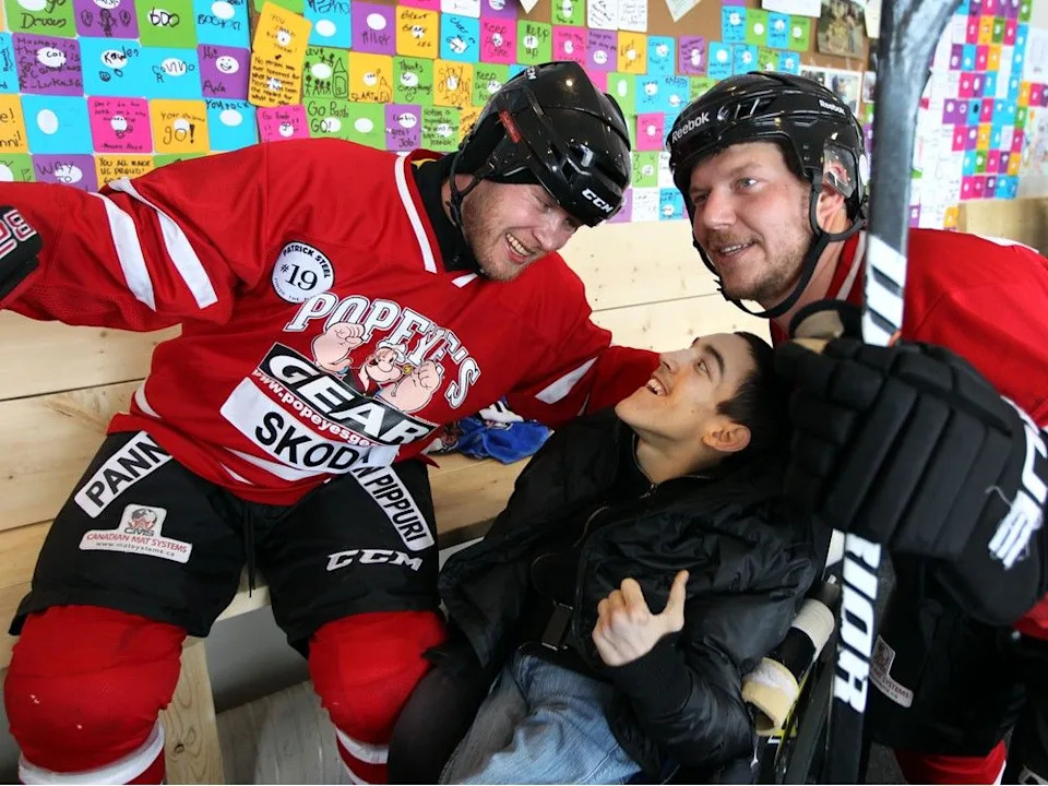  Ex-Edmonton Oilers defenceman Janne Niinimaa (left) shares a laugh with Mitchell Siminiuk (centre) and his brother Matt Siminiuk at the World’s Longest Hockey Game in Sherwood Park, Alberta on Sunday, Feb.15, 2015.