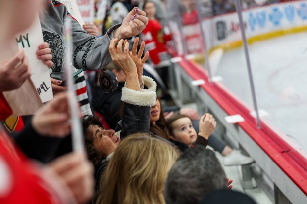 Fans get a puck from Chicago Blackhawks defenseman Connor Murphy (5) before the Chicago Blackhawks play the San Jose Sharks at the United Center Monday Feb. 2, 2026 in Chicago. (Armando L. Sanchez/Chicago Tribune)