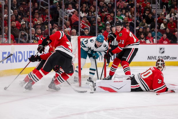 Chicago Blackhawks defenseman Alex Vlasic (72) guards San Jose Sharks center Macklin Celebrini (71) while he tries to score a goal past Chicago Blackhawks goaltender Spencer Knight (30) during the second period at the United Center Monday Feb. 2, 2026 in Chicago. (Armando L. Sanchez/Chicago Tribune)
