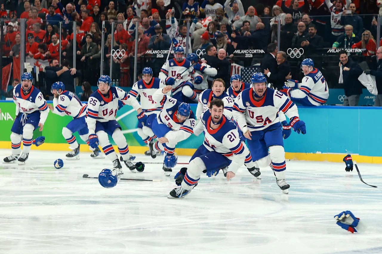 MILAN, ITALY - FEBRUARY 22: Players of Team United States celebrate a 2-1 victory against Canada in overtime for the gold medal during the Men's Gold Medal match between Canada and the United States on day 16 of the Milano Cortina 2026 Winter Olympic games at Milano Santagiulia Ice Hockey Arena on February 22, 2026 in Milan, Italy. (Photo by Elsa/Getty Images)