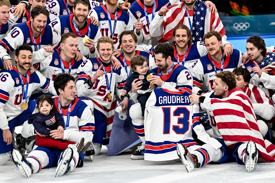 MILAN, ITALY - FEBRUARY 22: Team USA pose for a team photo with Johnny Gaudreau's children during the Ice Hockey Men's Gold Medal Game match between Canada and USA on day sixteen of the Milano Cortina 2026 Winter Olympic games at Milano Santagiulia Ice Hockey Arena on February 22, 2026 in Milan, Italy. (Photo by Andrea Branca/Eurasia Sport Images/Getty Images)