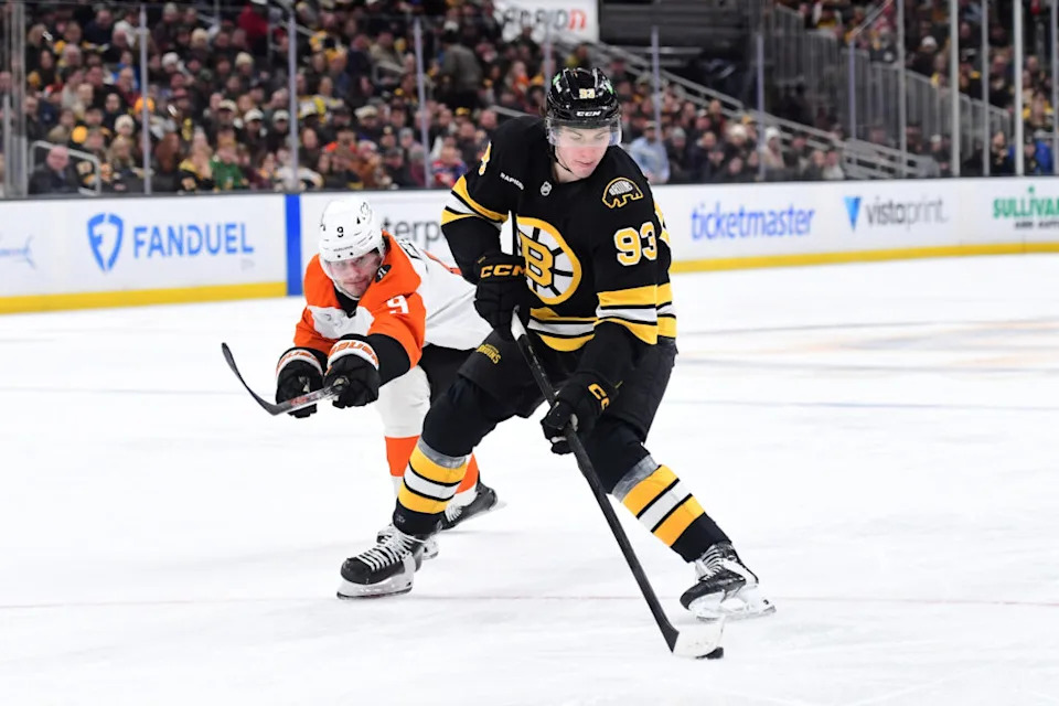Jan 29, 2026; Boston, Massachusetts, USA; Boston Bruins center Fraser Minten (93) controls the puck from Philadelphia Flyers defenseman Jamie Drysdale (9) during the third period at TD Garden. Mandatory Credit: Bob DeChiara-Imagn Images