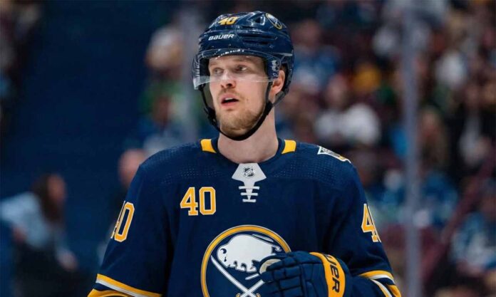 NHL player Elias Pettersson is pictured on an ice hockey rink wearing a dark blue Buffalo Sabres home jersey featuring the primary buffalo logo and number 40, along with a matching helmet and gloves, looking upwards to his left.