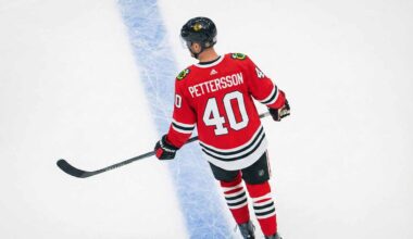 An overhead view of NHL player Elias Pettersson skating on an ice rink, wearing a red Chicago Blackhawks home uniform with the name "PETTERSSON" and number "40" on the back.