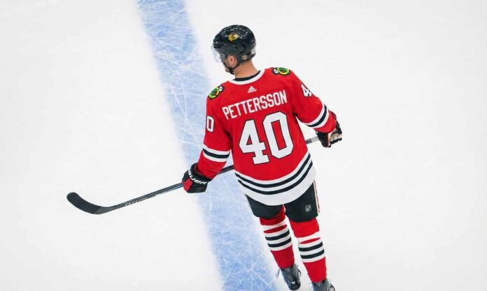 An overhead view of NHL player Elias Pettersson skating on an ice rink, wearing a red Chicago Blackhawks home uniform with the name "PETTERSSON" and number "40" on the back.