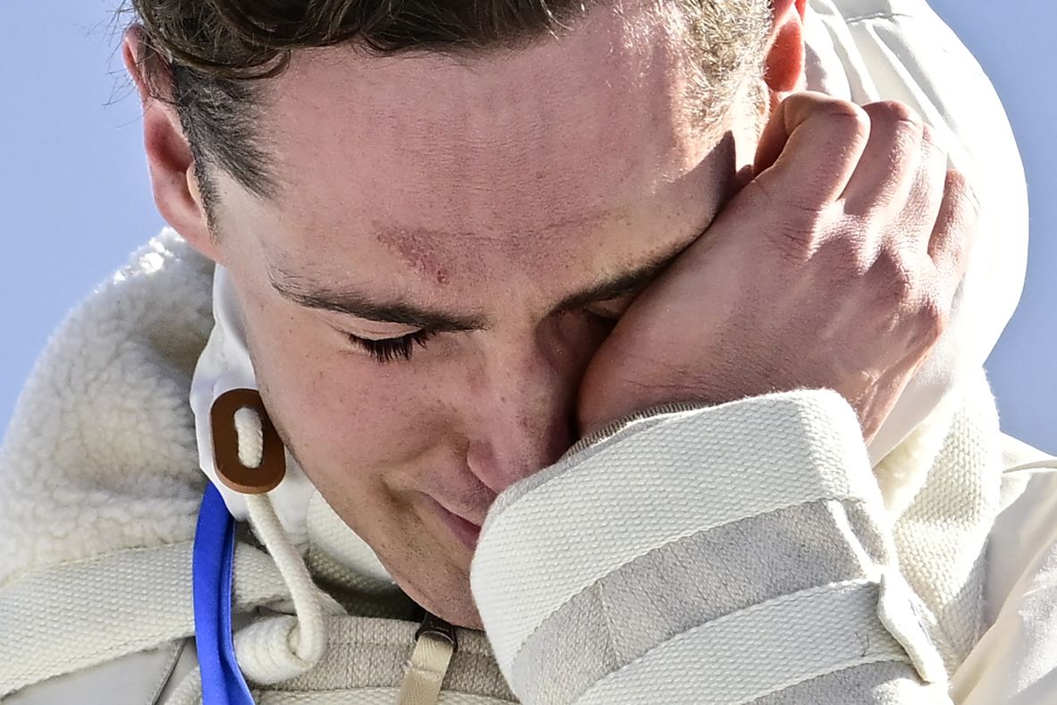 France's Mathis Desloges wipes a tear as he celebrates winning silver in the 10km + 10km skiathlon.