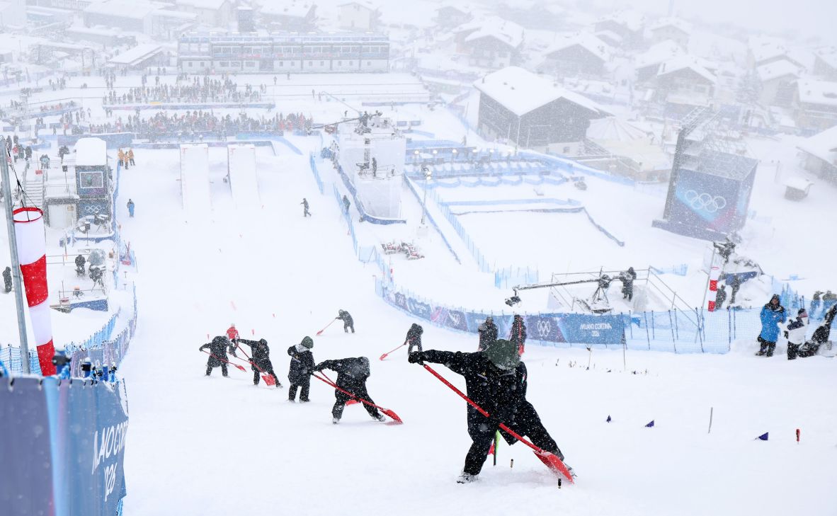 Workers clear snow as the women’s freeski aerials competition is delayed due to adverse weather conditions in Livigno, Italy, on February 17.