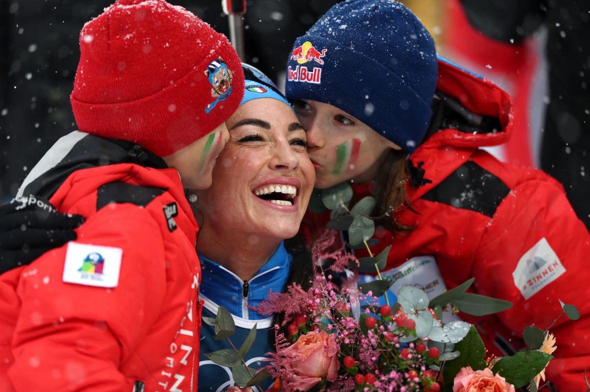Italy's Dorothea Wierer receives kisses from her children at the end of the women's biathlon 12.5km mass start event on February 21.