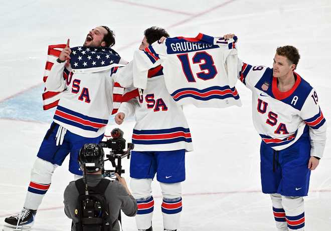 dpatop - 22 February 2026, Italy, Mailand: Olympia, Olympic Winter Games Milan Cortina 2026, ice hockey, men, Canada - USA, final round, final, USA players cheer for victory with a jersey of the late Johnny Gaudreau. Photo: Peter Kneffel/dpa (Photo by Peter Kneffel/picture alliance via Getty Images)