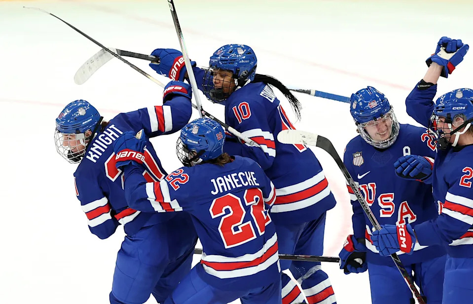 Knight celebrates with teammates on the ice after scoring a goal.