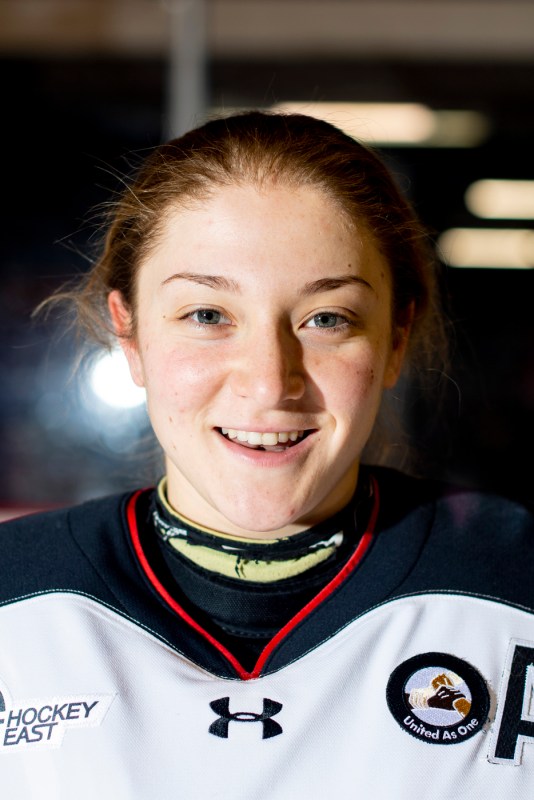 Aerin Frankel is smiling helmetless while dressed in hockey garb.