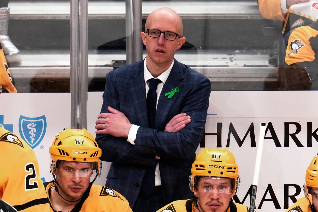 Pittsburgh Penguins coach Dan Muse observing a game from behind the bench.