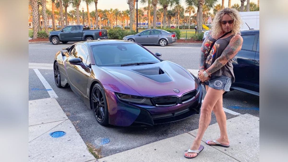 Robert Dorgan posing outdoors next to a sports car in an undated photo related to the Rhode Island shooting.